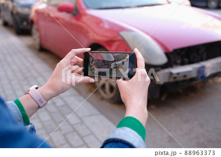 Female hands taking pictures of car damage on mobile phone closeup Female hands taking pictures of car damage on mobile phone closeup 88963373