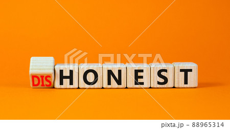 Honest or dishonest symbol. Turned cube and changed the concept word Dishonest to Honest. Beautiful orange table orange background. Business and honest or dishonest concept. Copy space. 88965314