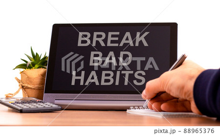 Break bad habits symbol. Tablet with words 'break bad habits'. Businessman hand with pen, house plant. Beautiful white background. Business, psychology and break bad habits concept, copy space. Break bad habits symbol. Tablet with words 'break bad habits'. Businessman hand with pen, house plant. Beautiful white background. Business, psychology and break bad habits concept, copy space. 88965376