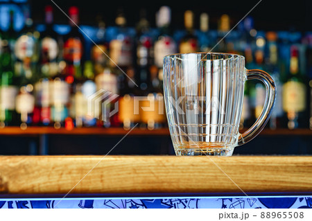 Empty beer glass on a wooden bar counter Empty beer glass on a wooden bar counter 88965508