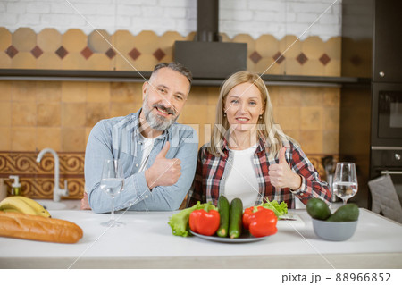 Portrait of mature couple posing in embrace on kitchen 88966852