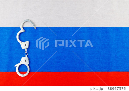 silver metal opened handcuffs laid on Russian flag full-frame background silver metal opened handcuffs laid on Russian flag full-frame background 88967576