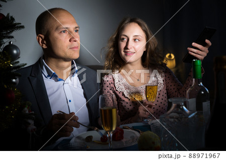 Wife and husband are watching TV on Christmas night 88971967