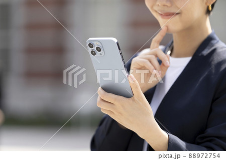 スマートフォンを持つビジネスウーマンの手元 88972754