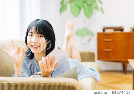 スマホを持ってOKサインをする女性 スマホを持ってOKサインをする女性 88974410