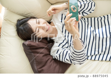 動画配信をスマホで見る主婦 88975045
