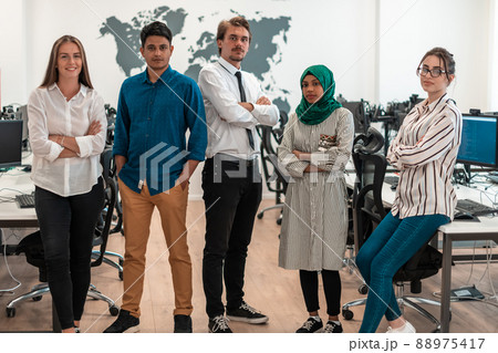 Portrait of young excited multiethnics business team of software developers standing and looking at camera at modern startup office 88975417