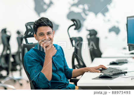 Casual business man working on desktop computer in modern open plan startup office interior. Selective focus Casual business man working on desktop computer in modern open plan startup office interior. Selective focus 88975493