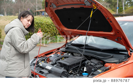 車のトラブルに困った顔の若い女性 88976787