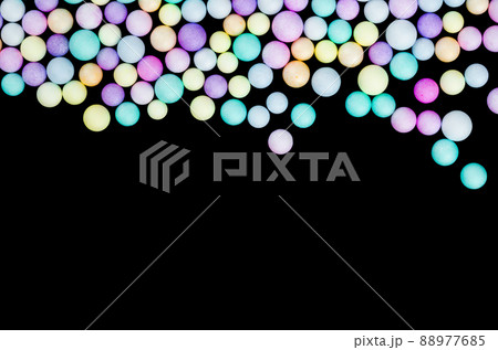 Foam beads of various colors brightly colored on black color background with empty space. Foam beads of various colors brightly colored on black color background with empty space. 88977685
