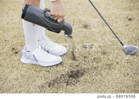 ダフった跡を目土する女子ゴルファー手元　ゴルフイメージ 88978506