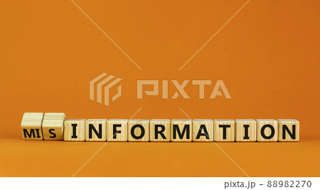 Information or misinformation symbol. Turned cubes and changed the word misinformation to information. Orange background, copy space. Business and information or misinformation concept. 88982270
