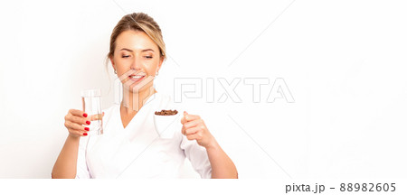 Coffee with water. The female nutritionist holds a cup of coffee beans and a glass of water in her hands on white background 88982605