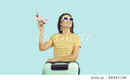Happy woman traveler with suitcase ready for vacation 88983186