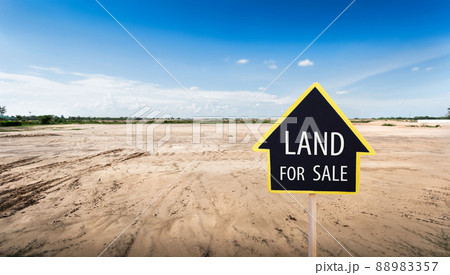 land for sale sign against trimmed lawn background. Empty dry cracked swamp reclamation soil, land plot for housing construction project in rural area and beautiful blue sky land for sale sign against trimmed lawn background. Empty dry cracked swamp reclamation soil, land plot for housing construction project in rural area and beautiful blue sky 88983357
