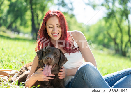 Young attractive woman hugs her dog in the park. 88984845