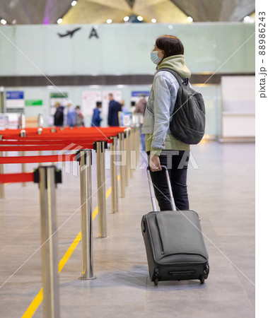 European woman at the airport waiting to board her flight, flight and boarding delays 88986243
