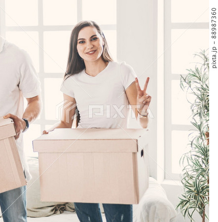 young family with cardboard boxes standing in a new apartment. young family with cardboard boxes standing in a new apartment. 88987360