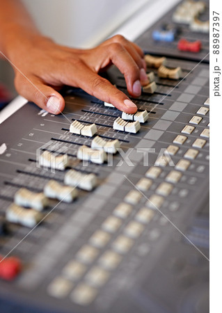 Fine-tuning the mix. Cropped close-up image of a hand moving a slider on a mixing desk. 88987397