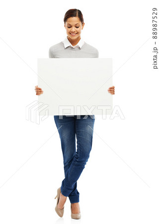 Presenting your message. Studio portrait of an attractive young woman holding a blank placard isolated on white. Presenting your message. Studio portrait of an attractive young woman holding a blank placard isolated on white. 88987529
