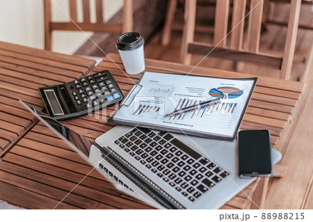 top view.takeaway coffee, financial chart, and laptop on coffee table. 88988215