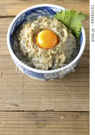 卵の黄身がトッピングされてる鯵のなめろう丼を俯瞰で撮影 88989281