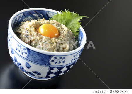 卵の黄身がトッピングされてる鯵のなめろう丼を黒背景で撮影 卵の黄身がトッピングされてる鯵のなめろう丼を黒背景で撮影 88989372
