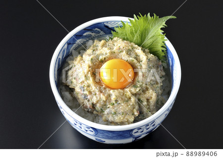 卵の黄身がトッピングされてる鯵のなめろう丼を黒背景で俯瞰撮影 88989406