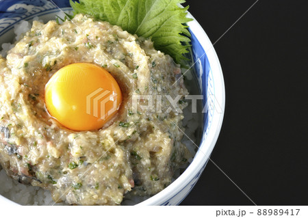 卵の黄身がトッピングされてる鯵のなめろう丼を黒背景で俯瞰撮影 卵の黄身がトッピングされてる鯵のなめろう丼を黒背景で俯瞰撮影 88989417