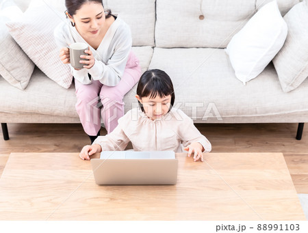 ノートパソコンを操作する子供と覗き込む母親　俯瞰撮影 88991103