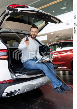 a satisfied customer demonstrates the keys of a new SUV a satisfied customer demonstrates the keys of a new SUV 88993260
