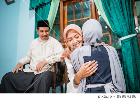 muslim daughter kneel and shake their parent's hand asking for forgiveness muslim daughter kneel and shake their parent's hand asking for forgiveness 88994386