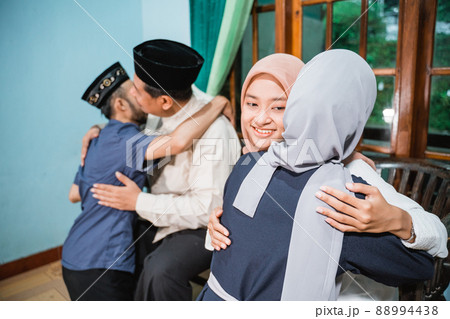 muslim family kneeling and hugging forgiving each other during eid mubarak muslim family kneeling and hugging forgiving each other during eid mubarak 88994438