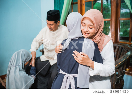 muslim family kneeling and hugging forgiving each other during eid mubarak muslim family kneeling and hugging forgiving each other during eid mubarak 88994439