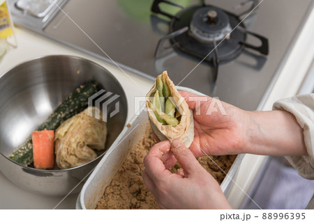 【出汁パックに入れて漬けた枝豆を糠床から取り出す】 【出汁パックに入れて漬けた枝豆を糠床から取り出す】 88996395