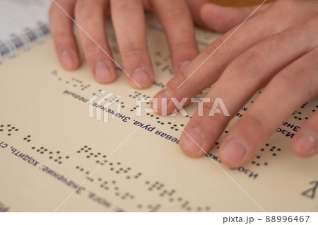 Visually impaired man reading a braille book. Visually impaired man reading a braille book. 88996467