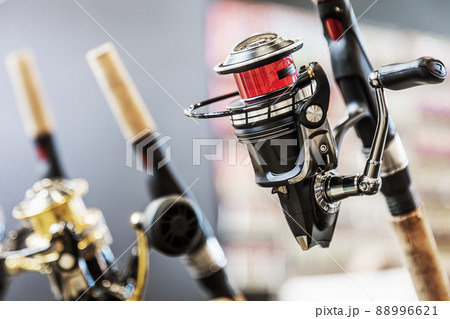an assortment of fishing reels on the counter of a fishing shop an assortment of fishing reels on the counter of a fishing shop 88996621