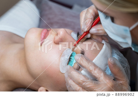 The master uses a multifunctional tool for laminating eyelashes. 88996902