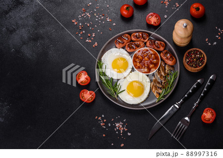 Full english breakfast with bean, fried eggs, roasted sausages, tomatoes and mushrooms Full english breakfast with bean, fried eggs, roasted sausages, tomatoes and mushrooms 88997316