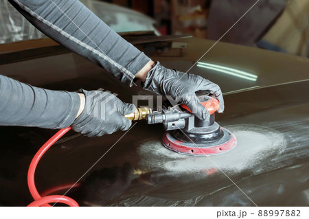 Grinding body parts with a pneumatic grinder before painting. 88997882