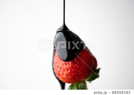 pouring chocokate sauce on strawberry 88998385