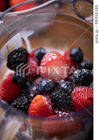 Pregnant woman pouring milk into a blender for preparing smoothie, partial  view Stock Photo - Alamy