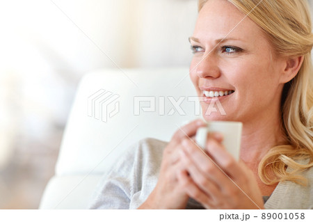 Nothing better than a fresh cup of coffee. Shot of a woman enjoying a cup of coffee at home. Nothing better than a fresh cup of coffee. Shot of a woman enjoying a cup of coffee at home. 89001058