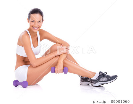 Ready to get your workout on. Studio portrait of an woman in exercise clothing sitting on the floor with dumbbells isolated on white. Ready to get your workout on. Studio portrait of an woman in exercise clothing sitting on the floor with dumbbells isolated on white. 89001060