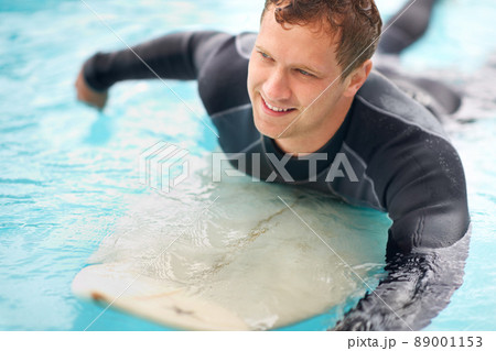 When in doubt, paddle out. Shot of a handsome young man enjoying a surf in clear blue water. When in doubt, paddle out. Shot of a handsome young man enjoying a surf in clear blue water. 89001153