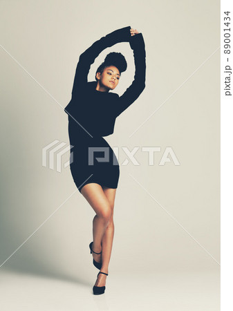 The little black dress, simple yet stand out style. Studio shot of a fashionable young woman posing in a black dress. The little black dress, simple yet stand out style. Studio shot of a fashionable young woman posing in a black dress. 89001434