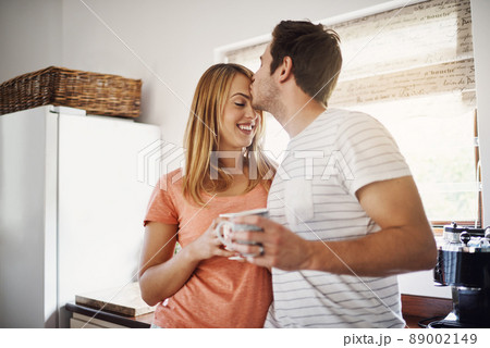 Mornings made with love. Shot of an affectionate young couple enjoying coffee together in the morning at home. 89002149