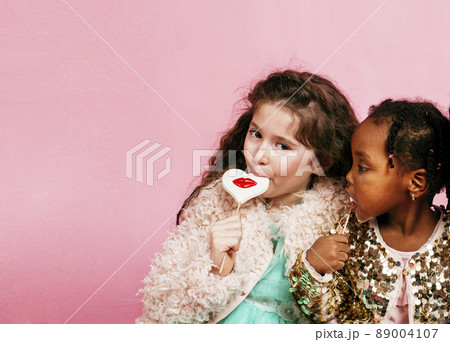 lifestyle people concept: diverse nation children playing together, caucasian boy with african little girl holding candy happy smiling lifestyle people concept: diverse nation children playing together, caucasian boy with african little girl holding candy happy smiling 89004107