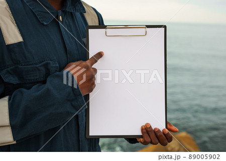 Seaman onboard a ship fills checklist. Paperwork at sea, Seaman onboard a ship fills checklist. Paperwork at sea, 89005902