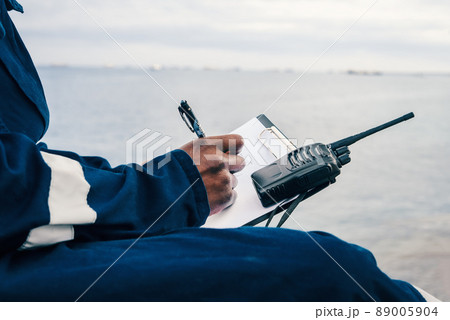 Seaman onboard a ship fills checklist. Paperwork at sea, Seaman onboard a ship fills checklist. Paperwork at sea, 89005904